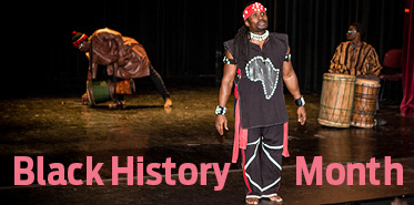 People performing on stage; text says Black History Month